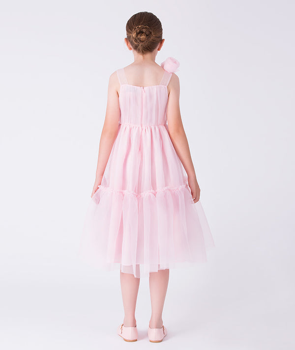 Young girl wearing a pink dress against a white background