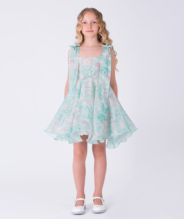 Young girl wearing a light blue floral dress on a white background