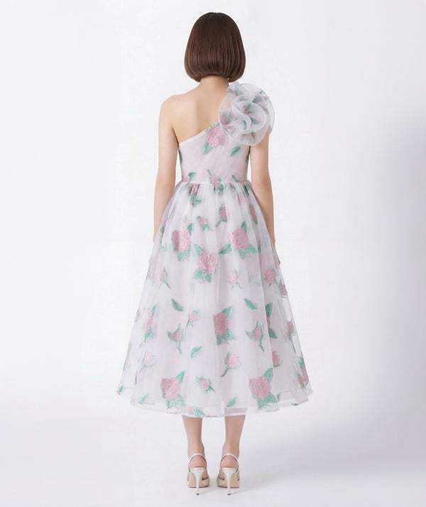 Woman wearing a floral one-shoulder dress on a white background