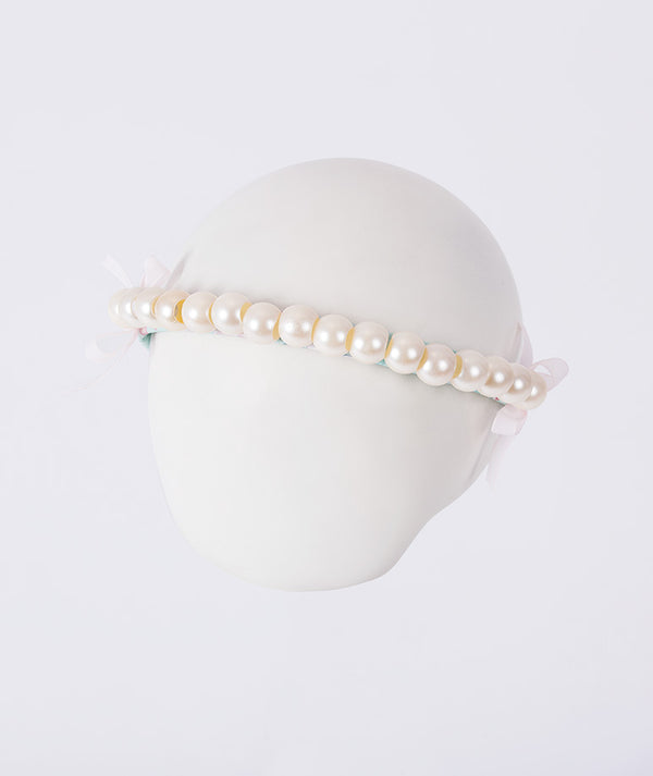 Pearl headband on a mannequin head against a white background