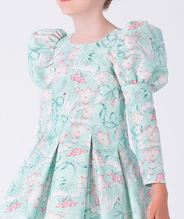 Child wearing a floral dress with puffed sleeves on a white background