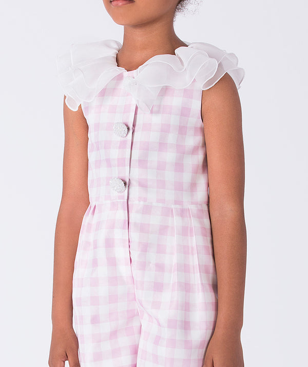 Close-up of the ruffled organza neckline and button detail on Mama Luma’s pink checkered girls romper, designed for refined occasions for ages 3–12.