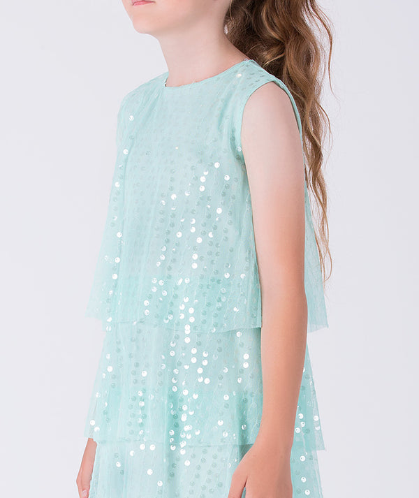 Light blue sequin dress worn by an 8 years old girl on a white background