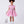 Load image into Gallery viewer, 6 YEARS OLD girl wearing a pink dress with white patterns, holding a matching bag, on a white background
