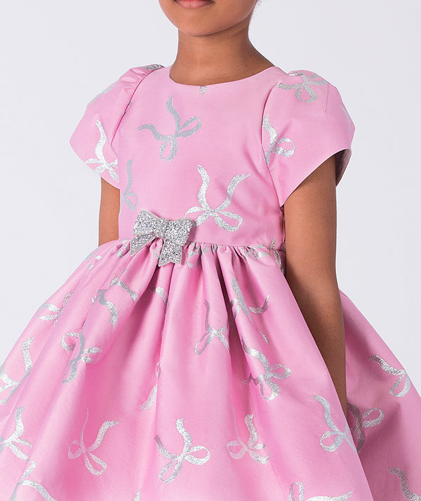 Pink dress with silver bow details on a white background