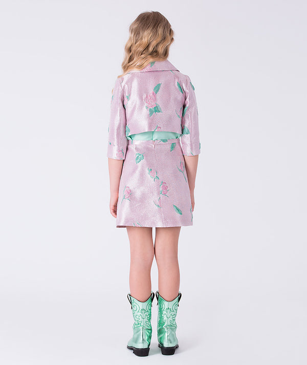 Girl wearing a pink floral dress with a white background