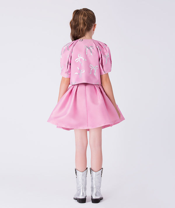 12 years old wearing a pink dress with white floral patterns on a white background