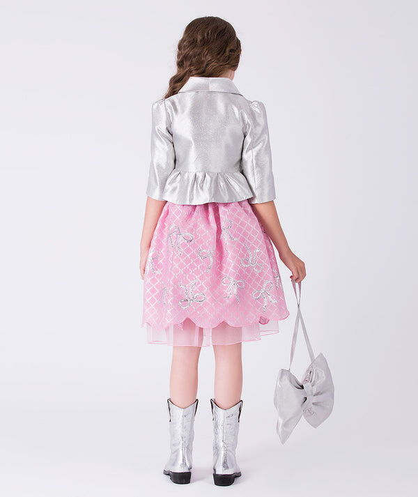 9 years old girl wearing a silver jacket, pink dress with floral patterns, and silver boots on a white background