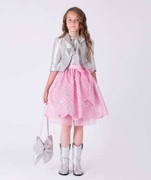 9 years old girl wearing a gray shirt, pink skirt, and silver boots on a white background