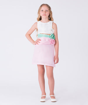 6 years old girl wearing a white top with floral details and a pink skirt on a white background