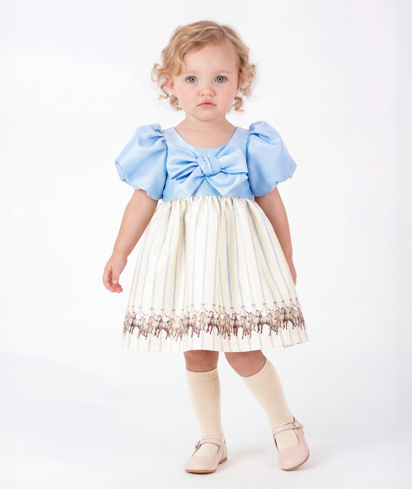 Front view of Altai Morin Baby Girls Dress featuring a baby-blue statement bow, puff sleeves and equestrian horse skirt by Mama Luma.