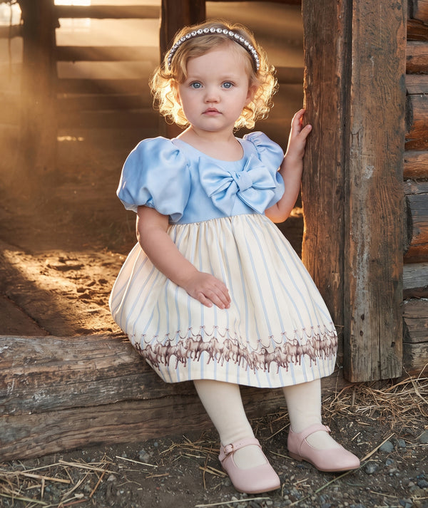 Altai Morin baby girls dress in baby blue with statement bow, puff sleeves and equestrian horse print by Mama Luma.