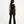 Load image into Gallery viewer, Girl seen from the back wearing a black sleeveless tank top and matching ribbed pants, styled for everyday athleisure, active play, and casual movement, available in sizes 3–14
