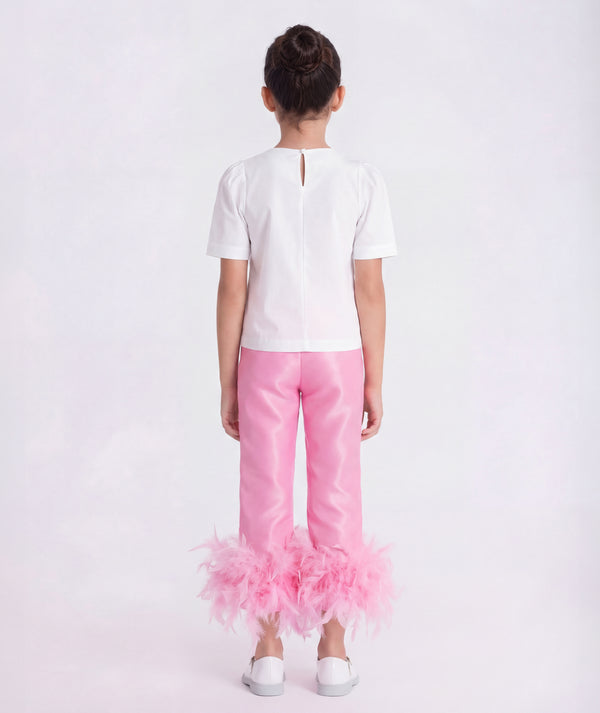 6 years old wearing a white top and pink pants with feathered bottom half on a white background