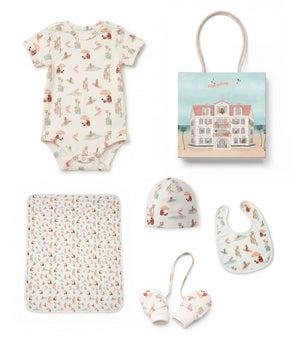 Baby clothing and accessories set with a onesie, hat, bib, and more on a white background.