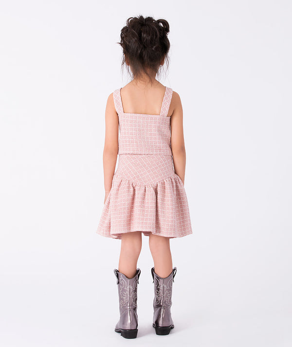 Back view of a blush pink tweed girls’ dress with wide straps and a flared skirt — a chic and playful look for birthdays, afternoon outings, and spring celebrations. Available in sizes 3–12Y