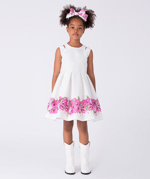 Luxury girls occasion dress in white with crystal bougainvillea floral detailing, sleeveless silhouette and flared skirt designed for special events