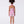 Load image into Gallery viewer, Back view of a bougainvillea print girls jumper with open halter back and comfortable fit, worn by a 7-year-old girl for warm-weather events.
