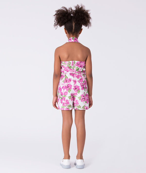Back view of a bougainvillea print girls jumper with open halter back and comfortable fit, worn by a 7-year-old girl for warm-weather events.