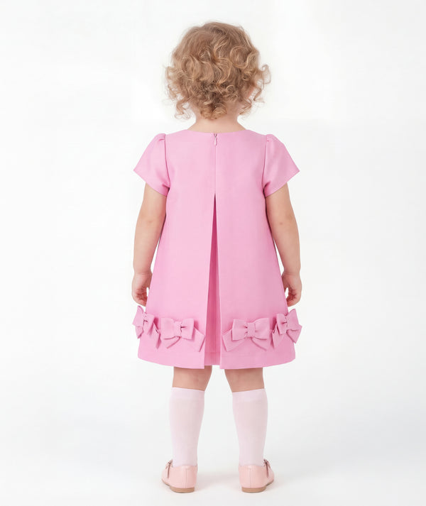 Back view of Bow-Pink Baby Dress showing its vibrant pink structured fabric finish for babies 12 to 36 months with refined designer construction