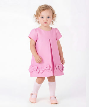 Front view of Bow-Pink Baby Dress in vibrant pink structured fabric for babies 12 to 36 months, styled as premium children’s special occasionwear