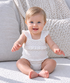 Baby wearing cozy knitted clothing in an editorial portrait.