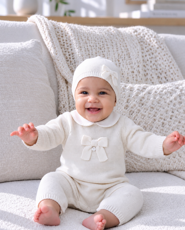 Smiling baby wearing cozy knitwear in an editorial portrait.