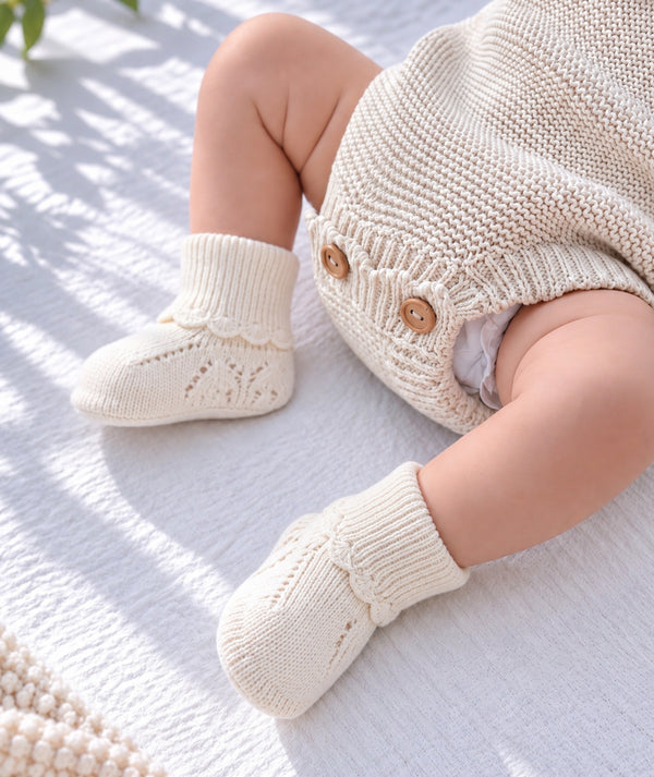 Baby wearing cozy knitwear, soft newborn clothing editorial.