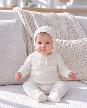 Baby portrait featuring a soft knitted bonnet and cozy baby clothing.