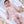Carica l'immagine nel visualizzatore Galleria, Pink knitted baby romper shown in a soft knitwear editorial.
