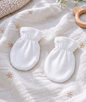 White baby knitwear in a product photograph.