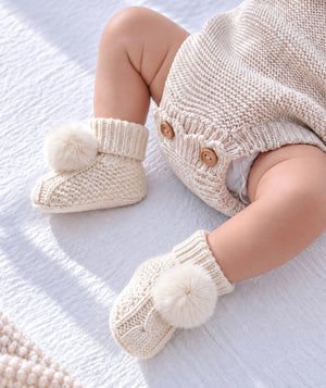 White puff baby booties, soft footwear for newborn outfits.