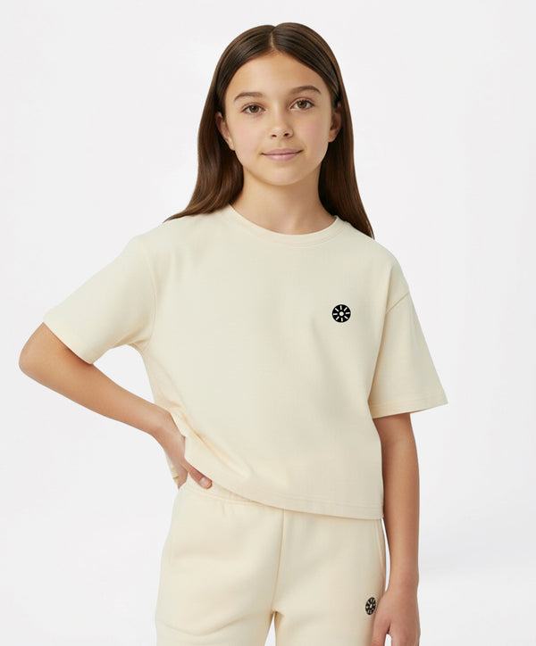 Cream short-sleeve girls active t-shirt with logo, perfect for school days, sports practice, playdates, and everyday comfort, available in sizes 3–14Y.