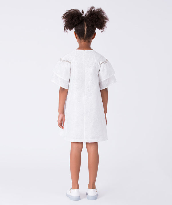 Back view of a white girls occasion dress featuring crystal shoulder details and a straight-cut silhouette for refined celebrations