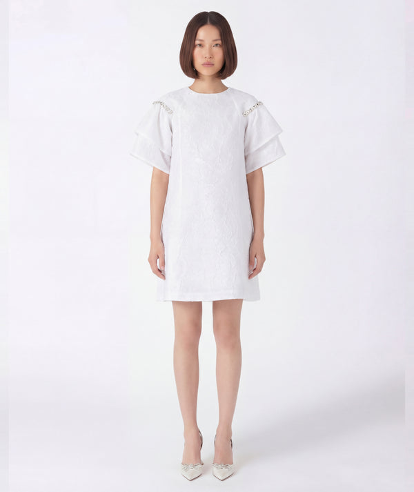 Woman wearing a white dress on a white background