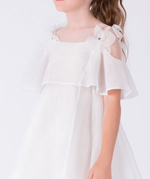 Close-up of crystal-centered floral appliqués on the shoulder straps of a sheer girls occasion dress with delicate craftsmanship