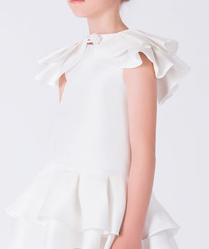 Close-up of layered ruffle sleeves and neckline detail on ivory girls occasion dress.