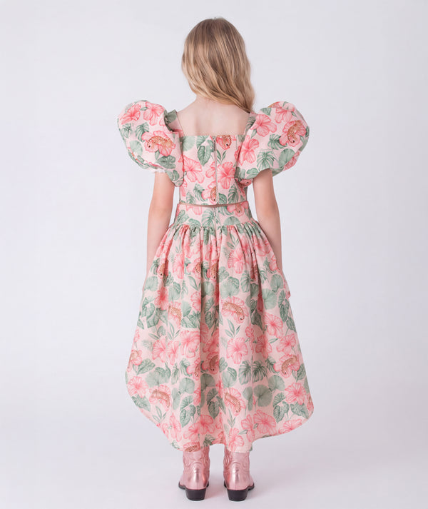 Back view of the Puff Sleeve High-Low Skirt Outfit featuring a puff-sleeve top with zip closure and a flowing high-low floral skirt made from breathable lightweight fabric, designed for girls ages 3–12 for Eid celebrations and garden events.