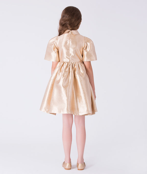 Back view of golden satin girls occasion dress with concealed zipper and softly gathered skirt silhouette.