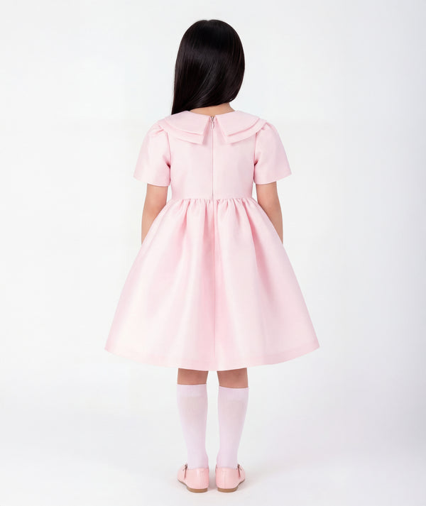 Back view of Enchanting Brooch Girls Dress in blush pink structured matte satin for girls ages 3 to 12, highlighting tailoring, closure and finishing