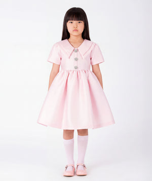 Front view of Enchanting Brooch Girls Dress in blush pink structured matte satin for girls ages 3 to 12, showing overall silhouette and styling