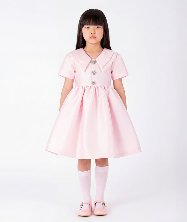 Front view of Enchanting Brooch Girls Dress in blush pink structured matte satin for girls ages 3 to 12, showing overall silhouette and styling