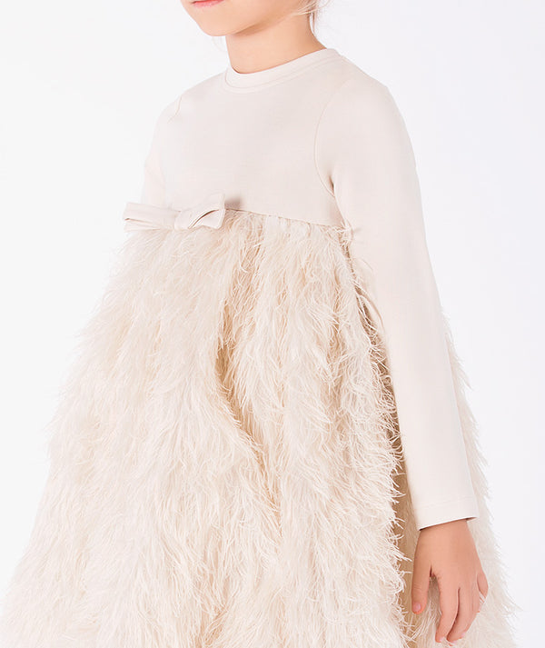 Detail view of Enchanting Feathers Girls Dress in beige featuring a tonal waist bow and soft feather-textured skirt by Mama Luma.