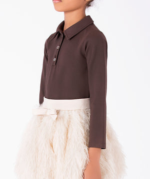 Detail view of Enchanting Feathers Girls Outfit featuring a chocolate collared top, ivory waistband, tonal bow and feather-textured skirt by Mama Luma.