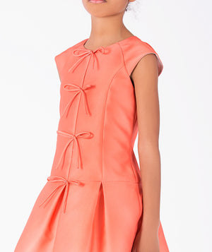 Close-up of Exquisite Bows Girls Dress in coral for girls ages 3 to 12, highlighting fabric texture and designer details