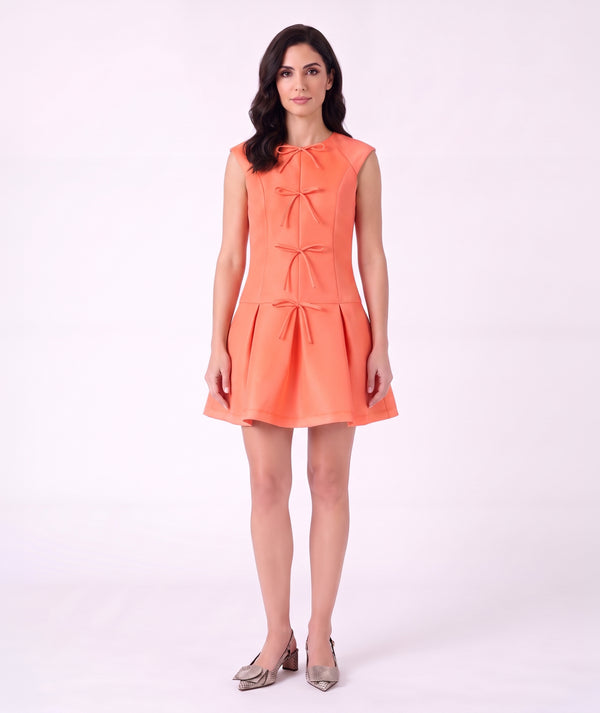 Front view of Exquisite Bows Women's Dress in coral with four tonal bows and a structured pleated mini skirt.