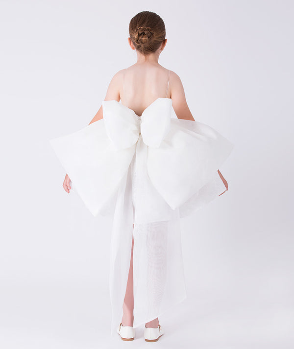 Back view of an exquisite jacquard girls dress with a statement bow detail and full skirt, worn by a 7-year-old girl for formal occasions
