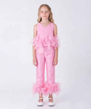Pink girls pants with voluminous feather cuffs styled for an elegant outdoor occasion