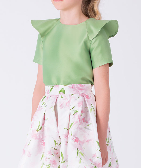 Close-up of the structured top and floral skirt in a two-piece girls outfit, highlighting refined tailoring and soft movement.