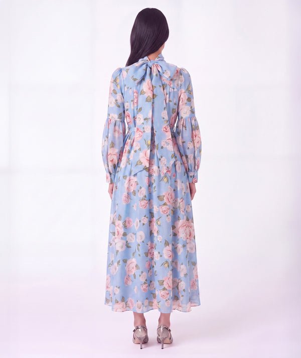Back view of Mama Luma Floral Bow Women's Dress with rose pattern, gathered sleeves and oversized neck bow
